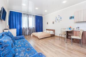 a living room with a bed and a table at Апартаменты Central Park на Таврической 9к1 in Tyumen