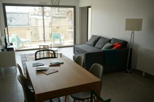 een woonkamer met een tafel en een bank bij Appartement Forum Reims in Reims