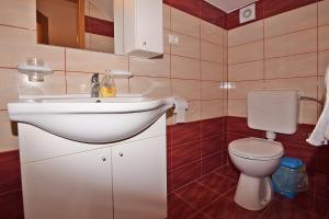 a bathroom with a white sink and a toilet at Apartments Jeromela in Fažana