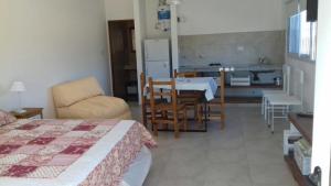 1 dormitorio con 1 cama y cocina con mesa en El esparto en Lobos