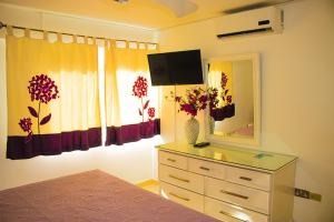 een slaapkamer met een dressoir met een spiegel en een dressoir met een jurk bij Surf Turf Two Bedroom Suite At Turtle Towers in Ocho Rios