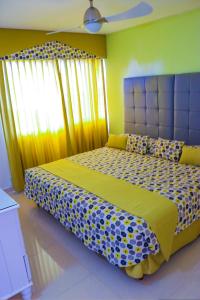 a bedroom with a large bed with a blue headboard at Surf Turf Two Bedroom Suite At Turtle Towers in Ocho Rios