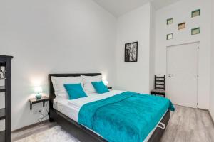 een slaapkamer met een bed met een blauwe deken erop bij Palace Residence in Boedapest