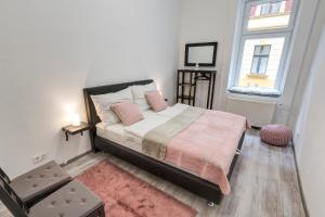 Un dormitorio con una cama con almohadas rosas y una ventana. en Palace Residence, en Budapest