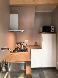 a kitchen with a sink and a stove and a microwave at Bardonecchia Holidays in Bardonecchia