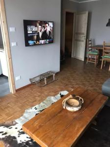 a living room with a wooden table and a tv at Bardonecchia Holidays in Bardonecchia
