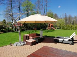 a patio with an umbrella and chairs and a playground at Willa Kisajno in Giżycko