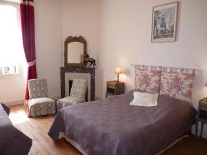 a bedroom with a bed and a chair and a mirror at La Maison d´Amazone in Mont-Disse