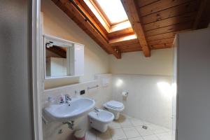 a bathroom with a sink and a toilet and a skylight at Casa Vacanze DalMolin in Valeggio sul Mincio