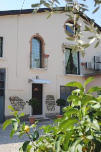 una casa blanca con plantas delante en Casa Vacanze DalMolin, en Valeggio sul Mincio