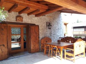 a wooden table and chairs on a patio at L’Invólt Mountain Lodge in Borno