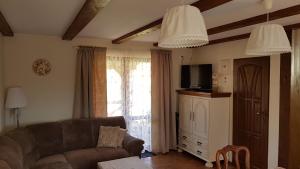a living room with a couch and a tv at Domek Piotr 2 in Stegna