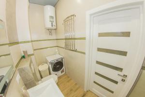 a bathroom with a washing machine and a toilet at Family Apartment in Odesa