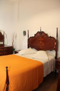 a bed with a white comforter and two pillows at Monte Sinai Guest House in Porto