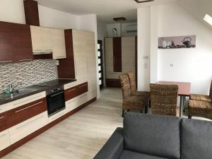 a kitchen and living room with a couch and a table at Kálvária Apartman in Baja