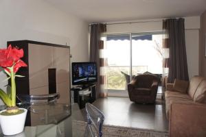 a living room with a couch and a tv at Sea view Penthouse with terrace in Cannes