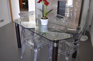 uma mesa de vidro com duas cadeiras e um vaso com flores em Sea view Penthouse with terrace em Cannes