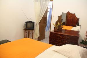 a bedroom with a bed and a tv at Monte Sinai Guest House in Porto