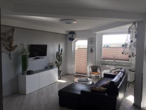 a living room with a couch and a tv at Apartament Bosmanski in Darlowko