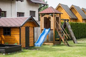 a playground with a blue slide and a gazebo at Domki na 102 in Junoszyno