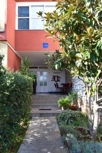 una casa con un sentiero che porta alla porta d'ingresso di Hostel Amfora a Fažana