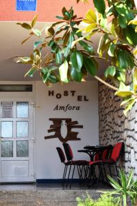 Hostel Amfora في فاجانا: طاوله وكراسي امام مدخل الفندق
