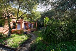 une maison avec des arbres et des fleurs dans la cour dans l'établissement Chez Régine et Serge, à Bandol