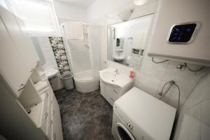 a white bathroom with a sink and a toilet at Sea Organ Apartment 1 & Garage for Free - Oldtown in Zadar