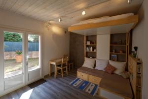 a bedroom with a bed and a desk and a window at Chez Régine et Serge in Bandol