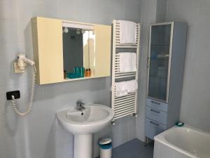 Un baño blanco con lavabo y espejo. en Darsena Apartment, en Génova 21 fotos más