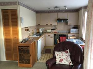 a small kitchen with a leather chair and a counter at Dream On in St Margarets at Cliff