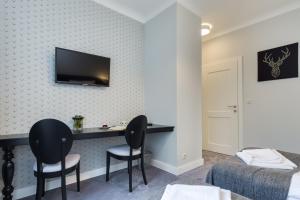 una camera d'albergo con scrivania e 2 sedie di 5 pokoi a Danzica