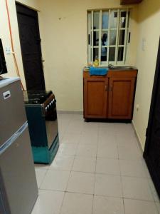a kitchen with a stove and a refrigerator in it at Solar and Inverter Full Service 3 Bedroom Flats in Ikeja