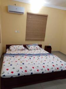 a bedroom with a bed with a white comforter at Solar and Inverter Full Service 3 Bedroom Flats in Ikeja