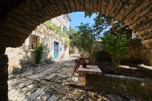 a stone alley with an archway with a bench in a building at La Boutique in Grožnjan