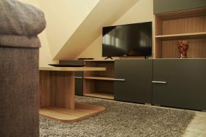 a living room with a tv and a cabinet with a table at Casa Toñi in Oia