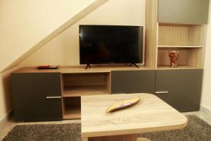 a living room with a television and a wooden table at Casa Toñi in Oia