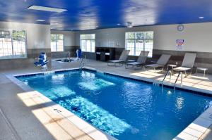 - une grande piscine avec des chaises et des tables dans une chambre dans l'établissement Microtel Inn & Suites by Wyndham Lubbock, à Lubbock