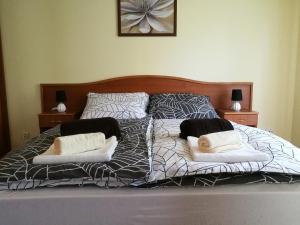 ヘーヴィーズにあるNiki Apartmanのベッド(白黒のシーツ、枕付)