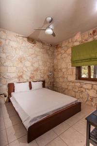 um quarto com uma cama e uma parede de pedra em Luxurious Stone House em Siviri