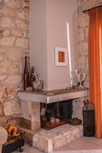 uma lareira de pedra numa sala de estar com uma parede de pedra em Luxurious Stone House em Siviri