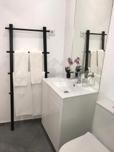 un bagno bianco con lavandino e specchio di Visit Lisbon4fun - Alfama a Lisbona Altre 15 foto
