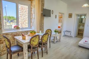 a dining room with a table and chairs and a window at Haraki Stone Apartments in Haraki