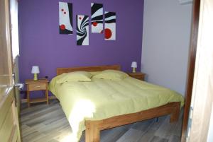 a bedroom with a bed with a purple wall at maison d en haut in Wintzenheim