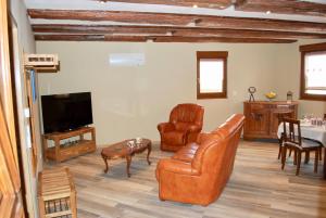 a living room with leather furniture and a flat screen tv at maison d en haut in Wintzenheim