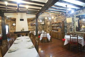 uma sala de jantar com mesas e cadeiras e paredes de pedra em Agroturismo Izarre em Régil