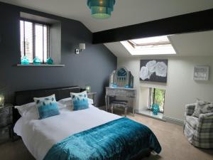 a bedroom with a large bed with a blue blanket at The Courtyard Cottage, Timble near Harrogate in Timble