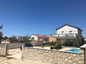 a house on the beach with a stone wall at Villa Santa Barbara in Vrsi