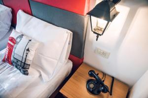 a bedroom with a bed and a table with a lamp at Hotel Everest Arco in Arco