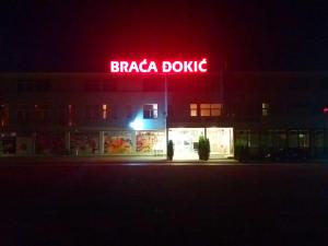 Un cartel de braccada doozy en un edificio por la noche en Guesthouse Đokić, en Leskovac